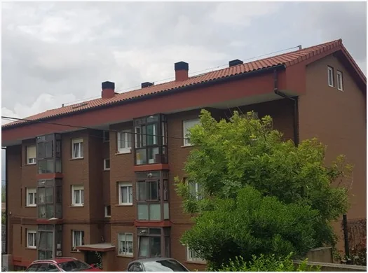 Edificio residencial con trabajos de fachada y cubierta